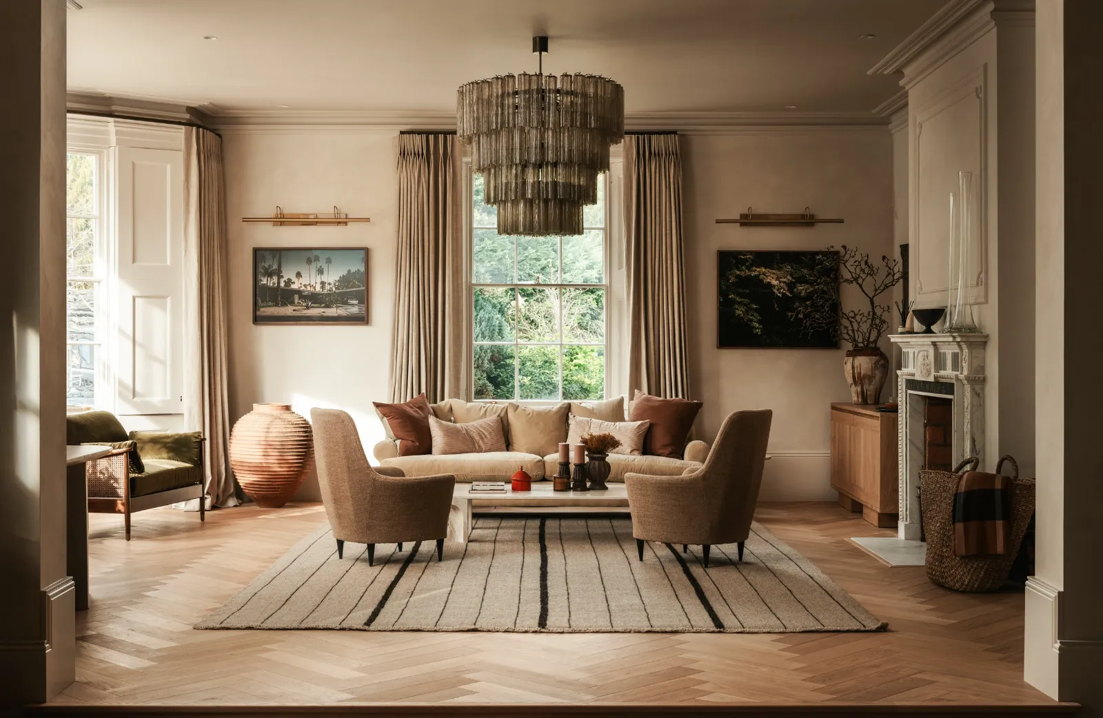 Sitting room with a statement chandelier, wall lights and layered lamp light