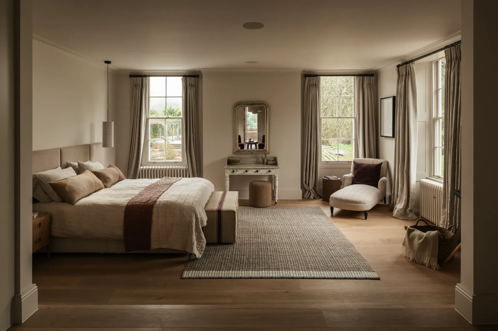 Bedroom with tall sash windows and full-length curtains